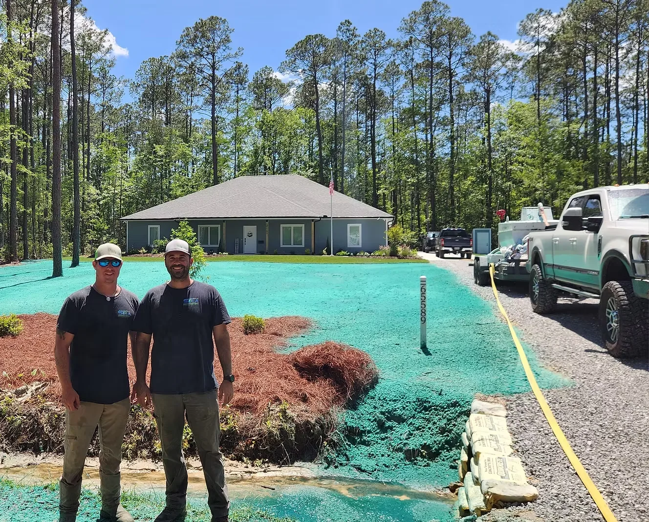 Tony and Ryan of Sola Hydroseeding standing beside company equipment